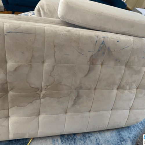 Tufted bench cushion with ink and water stains before cleaning
