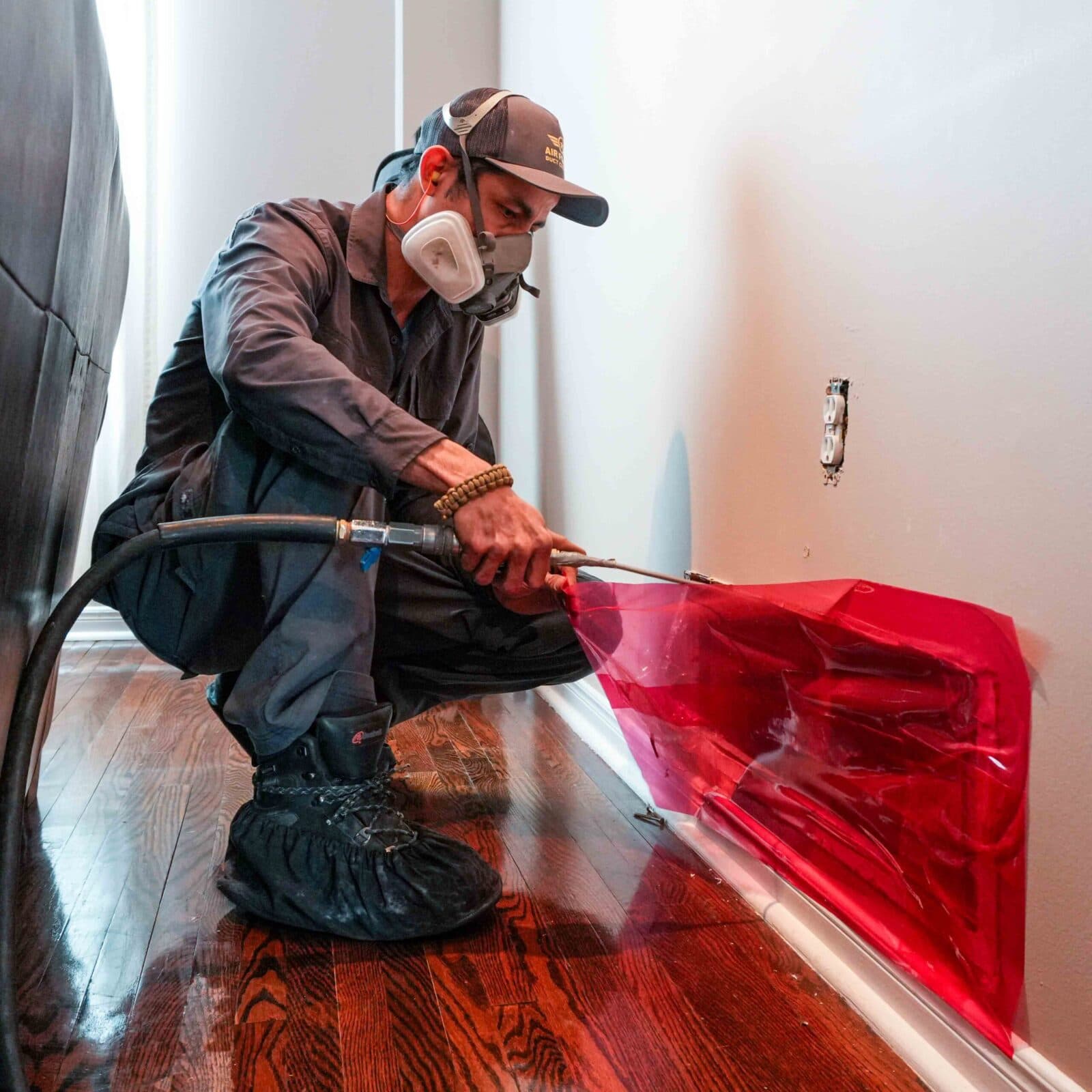 Technician sealing a baseboard vent before cleaning